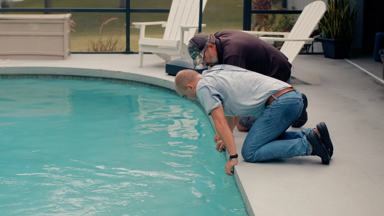 Two Advanced Leak Detection technicians inspecting a pool deck edge for leaks