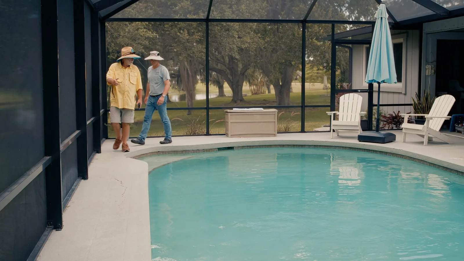 Advanced Leak Detection technician consulting with homeowners at their screened pool in Tampa Bay