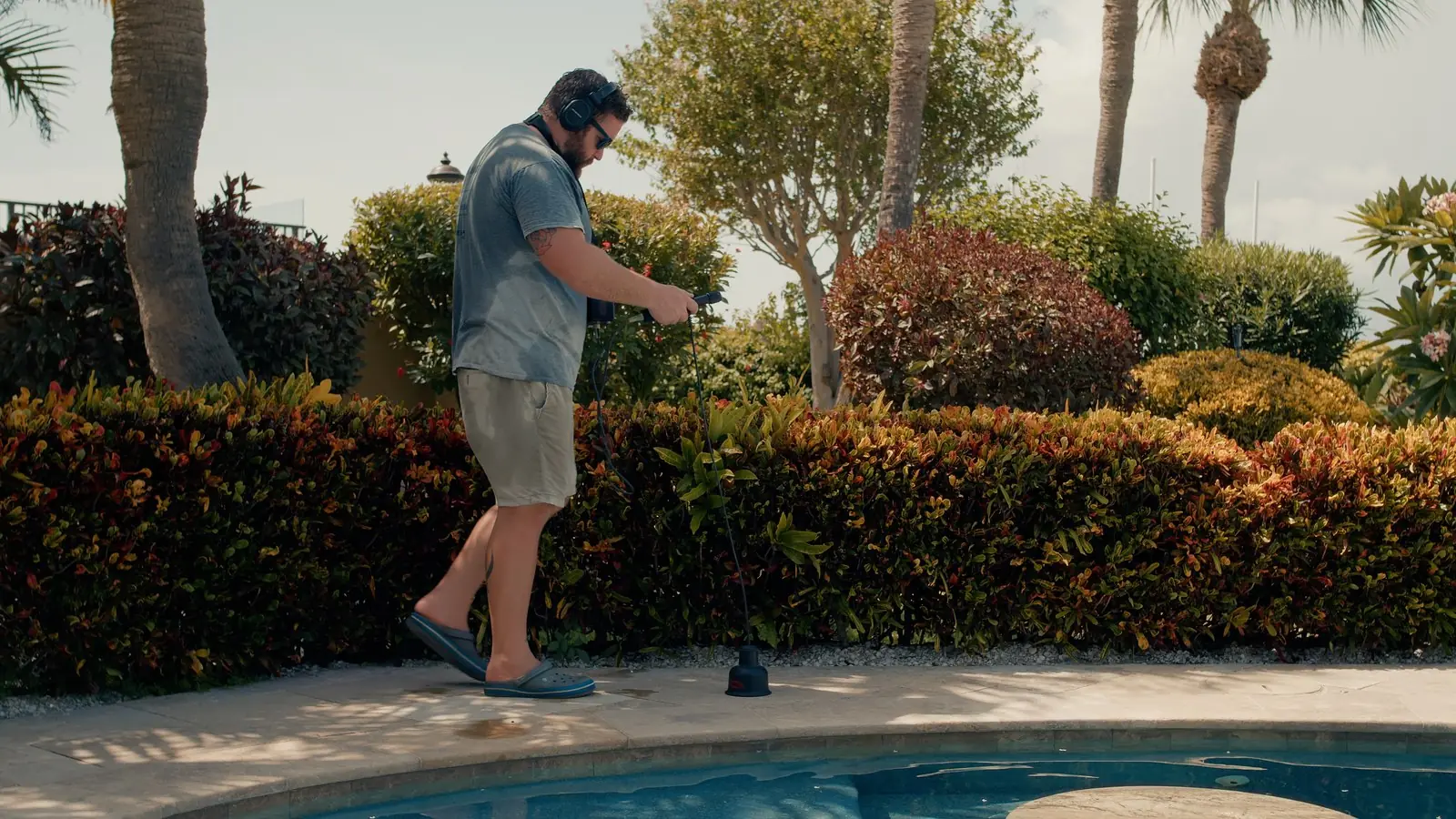 Advanced Leak Detection technician sweeping a Tampa Bay pool deck with electronic listening equipment to pinpoint an underground pool leak