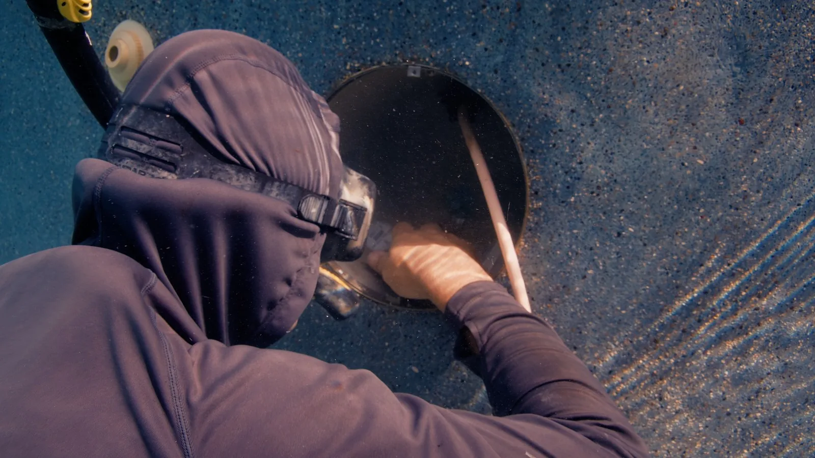 Diver repairing a leaking pool light niche underwater using the Deck Saver method