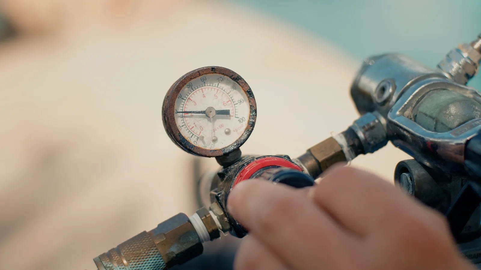 Technician reading a pressure gauge during a pool plumbing leak test in Saint Petersburg, Florida