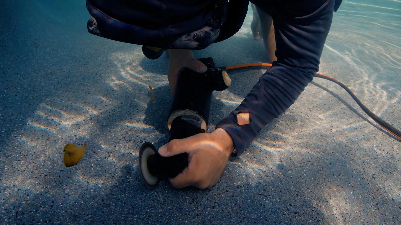 Advanced Leak Detection diver sealing a pool floor fitting underwater during a leak repair