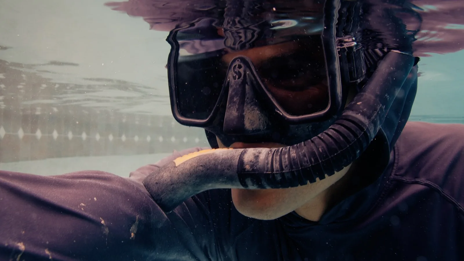 Close-up of an Advanced Leak Detection diver performing precision underwater repair work in a Tampa Bay pool