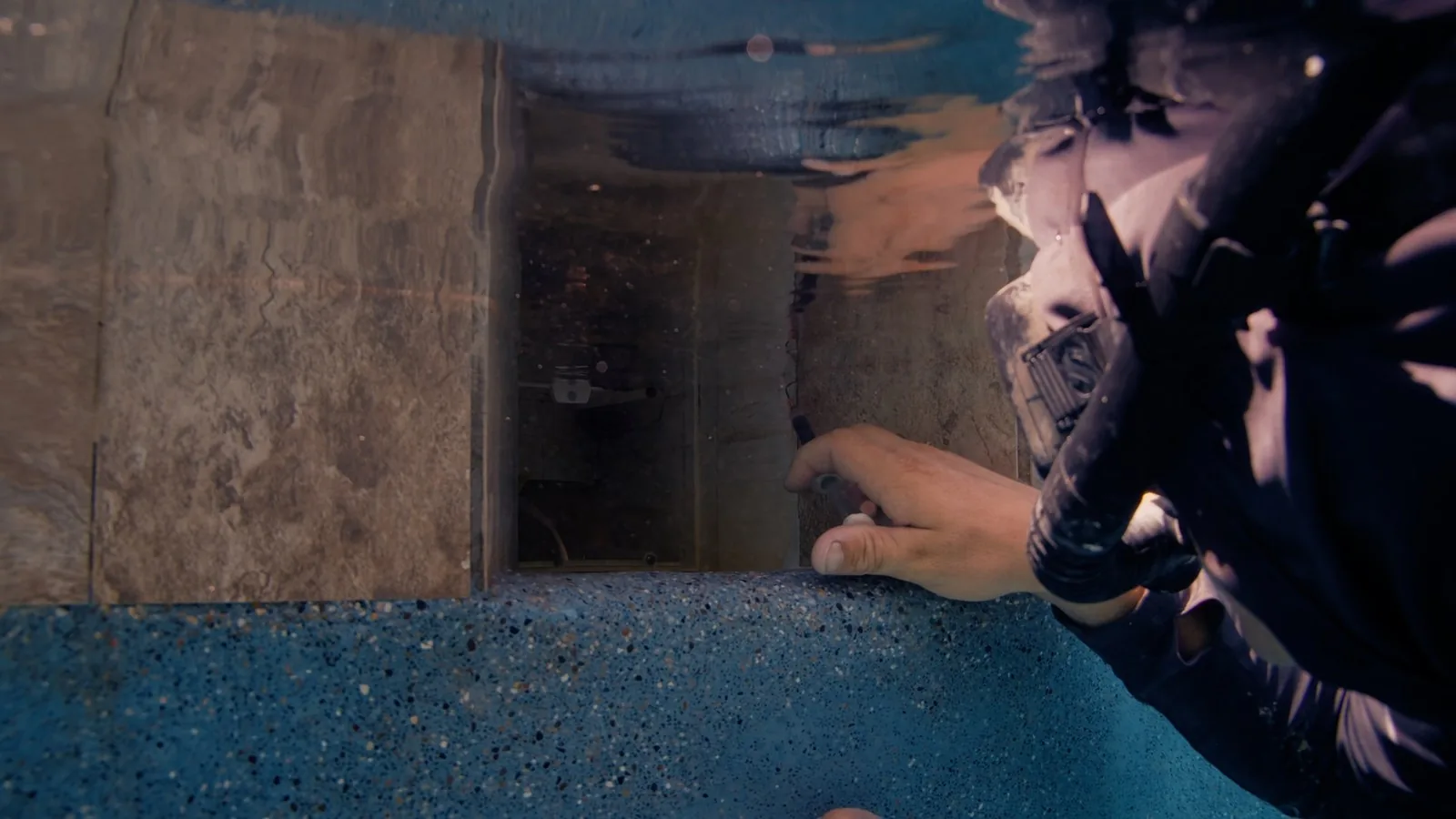 Two Advanced Leak Detection divers repairing a pool skimmer underwater without draining the pool