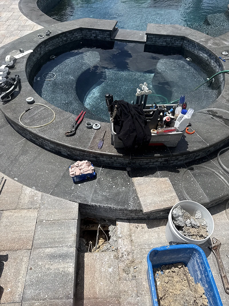 Poolside equipment beside a targeted deck access opening during an arthroscopic pipe repair.